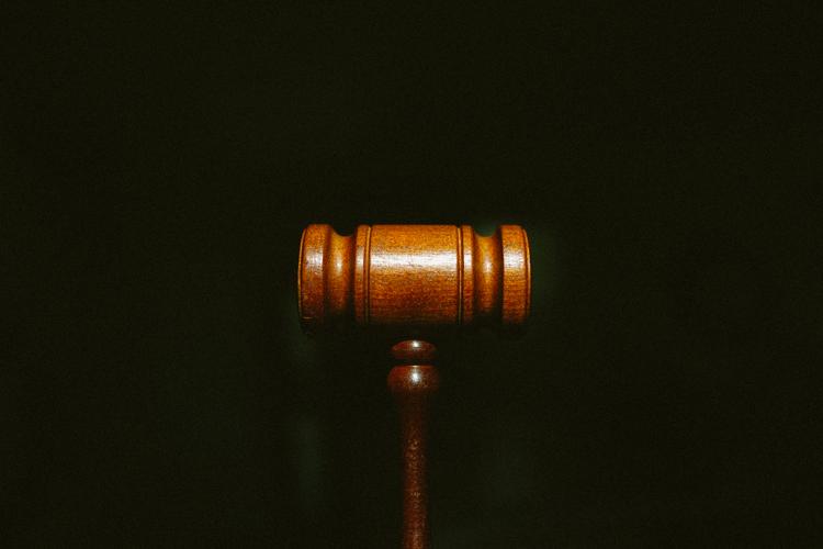 A wooden gavel over a black backdrop
